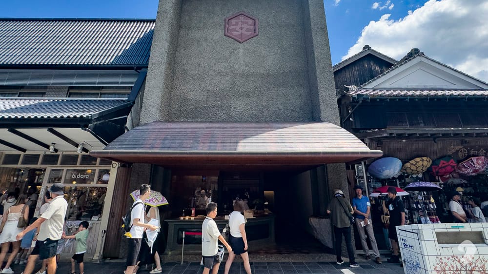 People visiting a historic stone structure along the approach in Dazaifu
