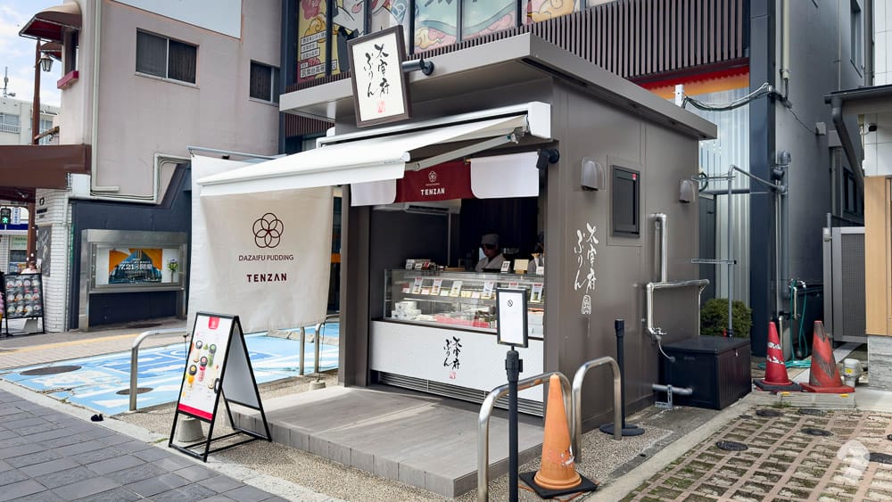Modern minimalist dessert stall counter with a white sign under an awning