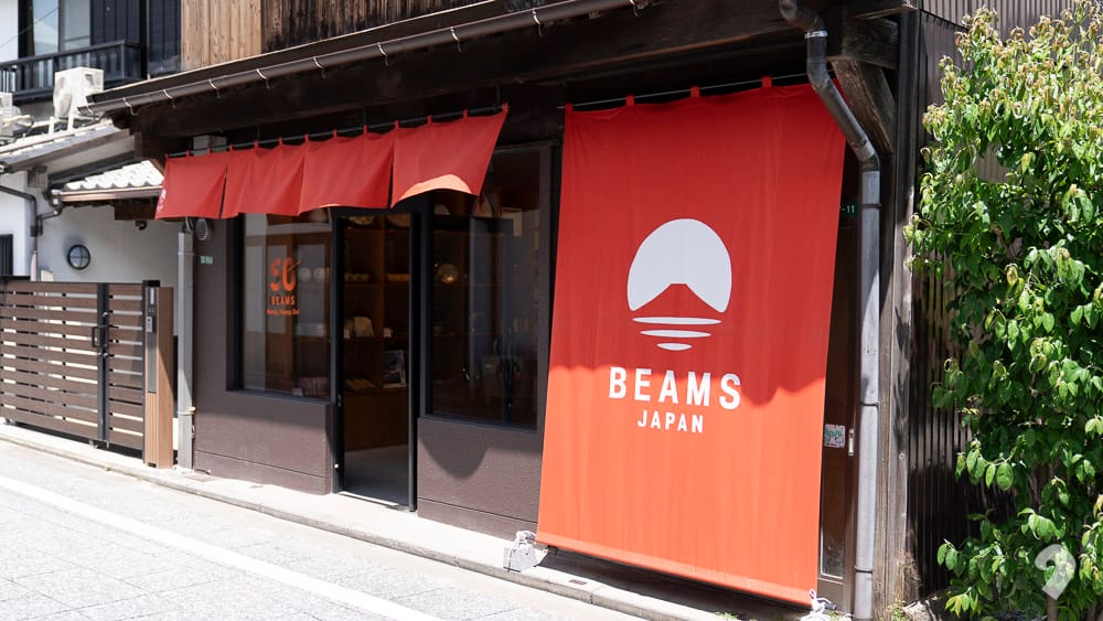 BEAMS JAPAN store entrance featuring a large red noren curtain with the logo