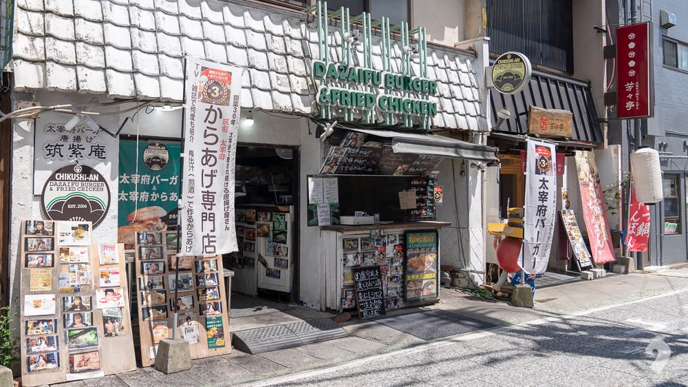 Dazaifu Burger and Fried Chicken shop entrance with banners on a sunny day