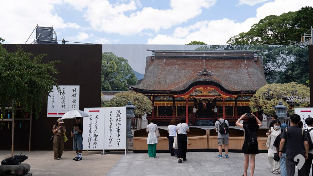 Main shrine building of Dazaifu Tenmangu Shrine with visitors praying in Fukuoka