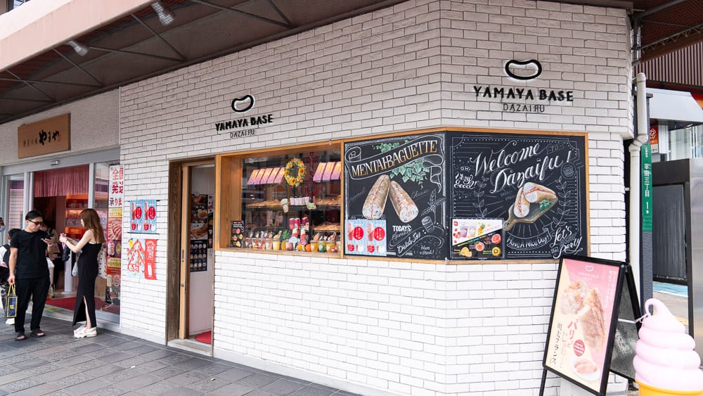 Yamaya Base Dazaifu storefront selling mentaiko snacks with a blackboard menu