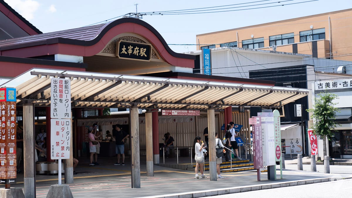 Dazaifu Station entrance exterior with passengers on a sunny day in Fukuoka, Japan